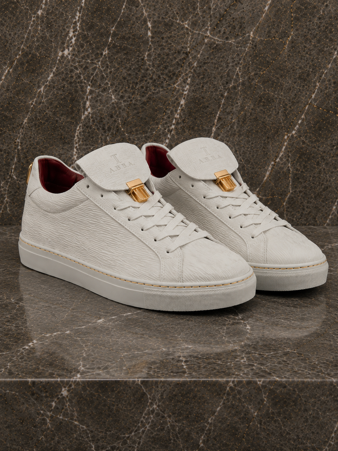 White sneakers with gold accents on a textured brown surface