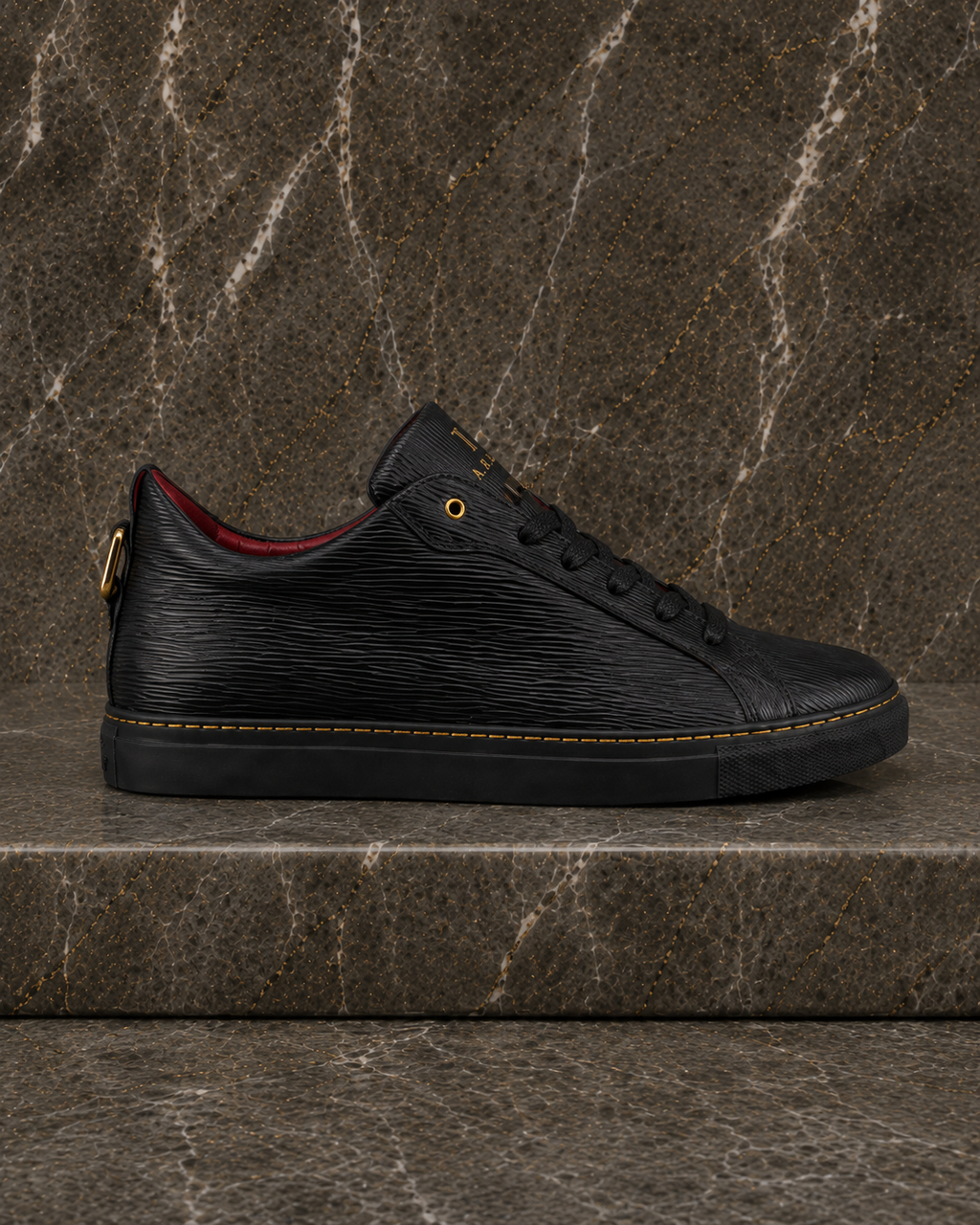 Side profile of A.B.B.A. Low C.Y.B.N. black calfskin sneaker with gold details and red lining
