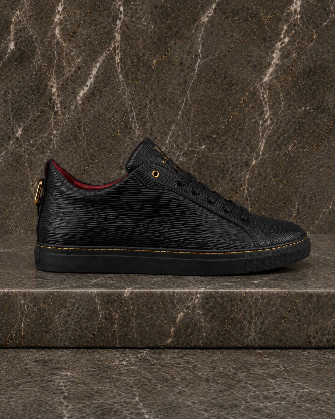 Side profile of A.B.B.A. Low C.Y.B.N. black calfskin sneaker with gold details and red lining